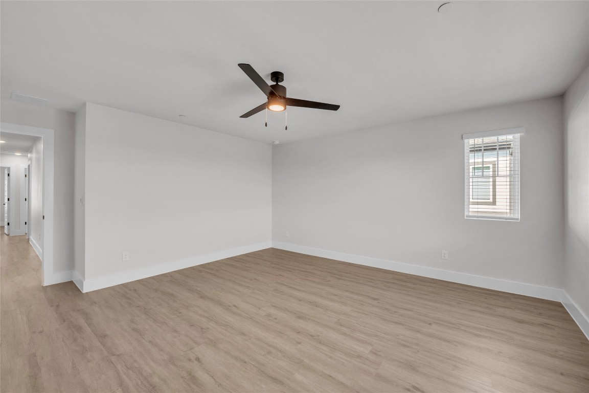9317 Curious Squirrel Street Austin, TX 78744 - Photo 9 of 26 a view of an empty room with a window and wooden floor