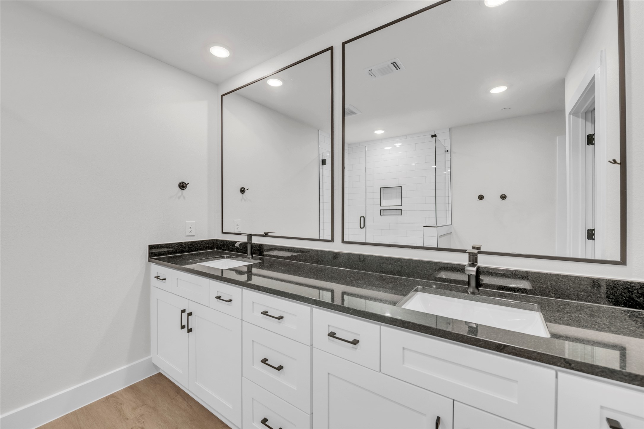 9317 Curious Squirrel Street Austin, TX 78744 - Photo 10 of 26 Bathroom featuring double vanity, a stall shower, light wood-style floors, and recessed lighting