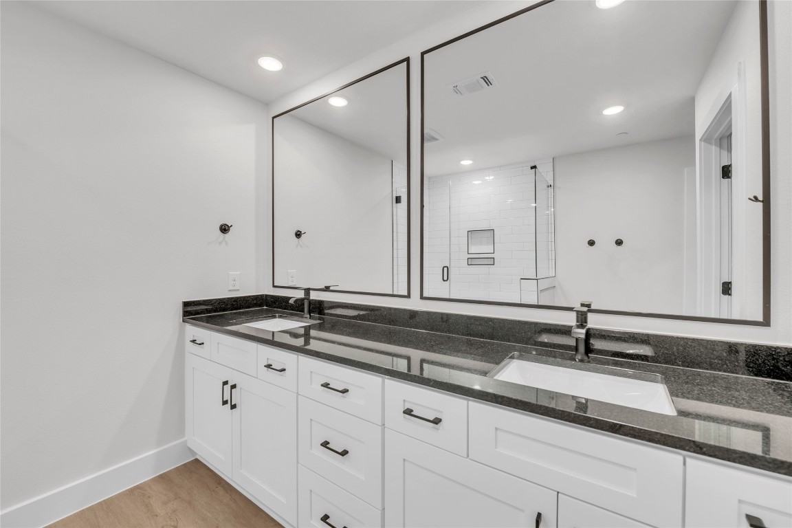 9317 Curious Squirrel Street Austin, TX 78744 - Photo 10 of 26 a sink with a granite countertop white vanity and a large mirror