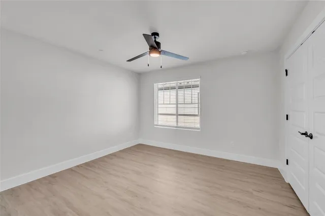 a view of room with hardwood floor and a ceiling fan