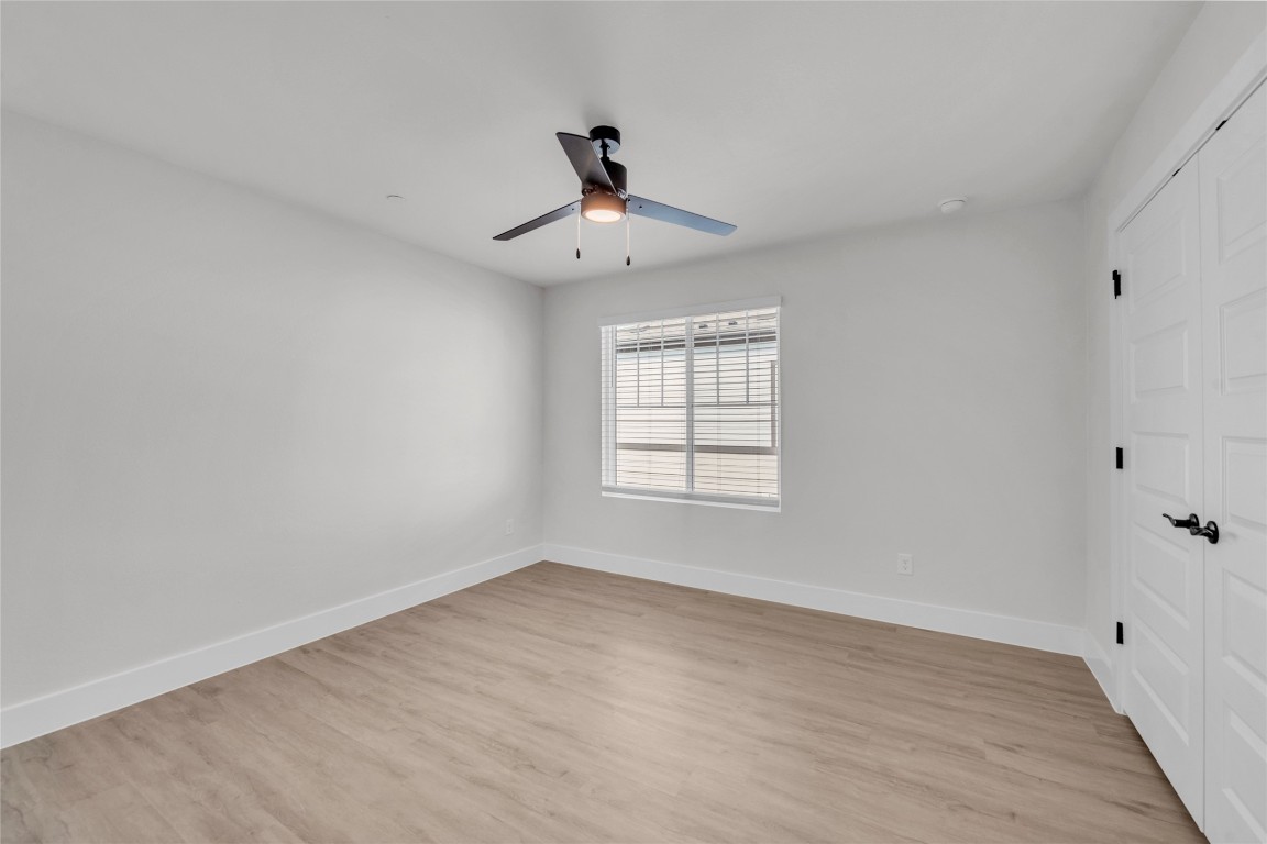 9317 Curious Squirrel Street Austin, TX 78744 - Photo 20 of 26 an empty room with wooden floor ceiling fan and windows