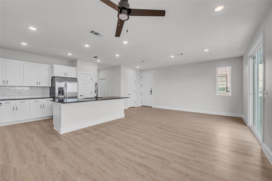 9317 Curious Squirrel Street Austin, TX 78744 - Photo 24 of 26 a large kitchen with stainless steel appliances granite countertop a large counter top a sink and a stove