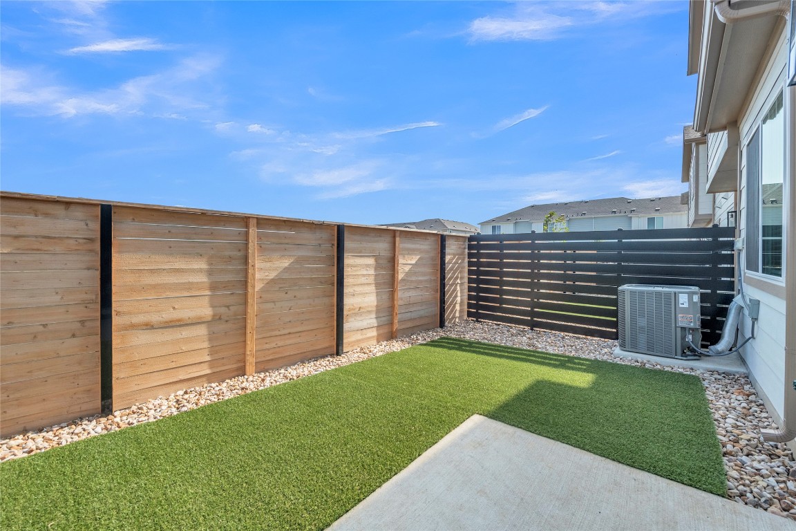9317 Curious Squirrel Street Austin, TX 78744 - Photo 4 of 26 a view of a backyard with plants and large tree
