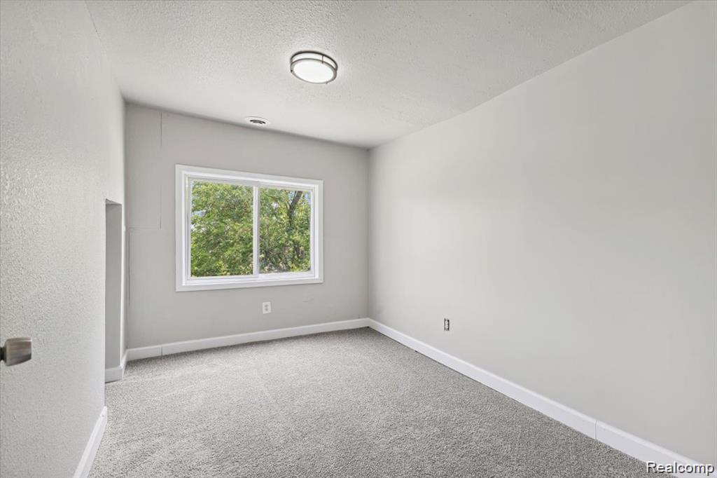 3140 Moore Street Inkster, MI 48141 - Photo 12 of 18 Room featuring light grey carpeting, white baseboards, and a window with white trim