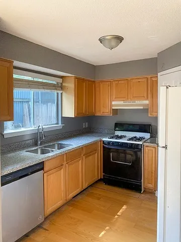 a kitchen with stainless steel appliances granite countertop a sink and a stove