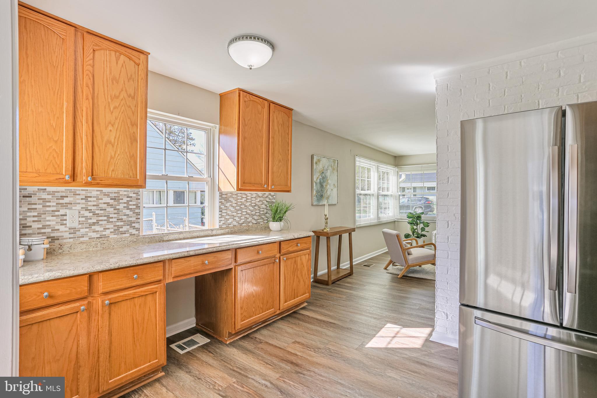 9939 Cottrell Terrace Silver Spring, MD 20903 - Photo 6 of 33 a open kitchen with stainless steel appliances granite countertop a refrigerator a sink dishwasher and wooden cabinets with wooden floor
