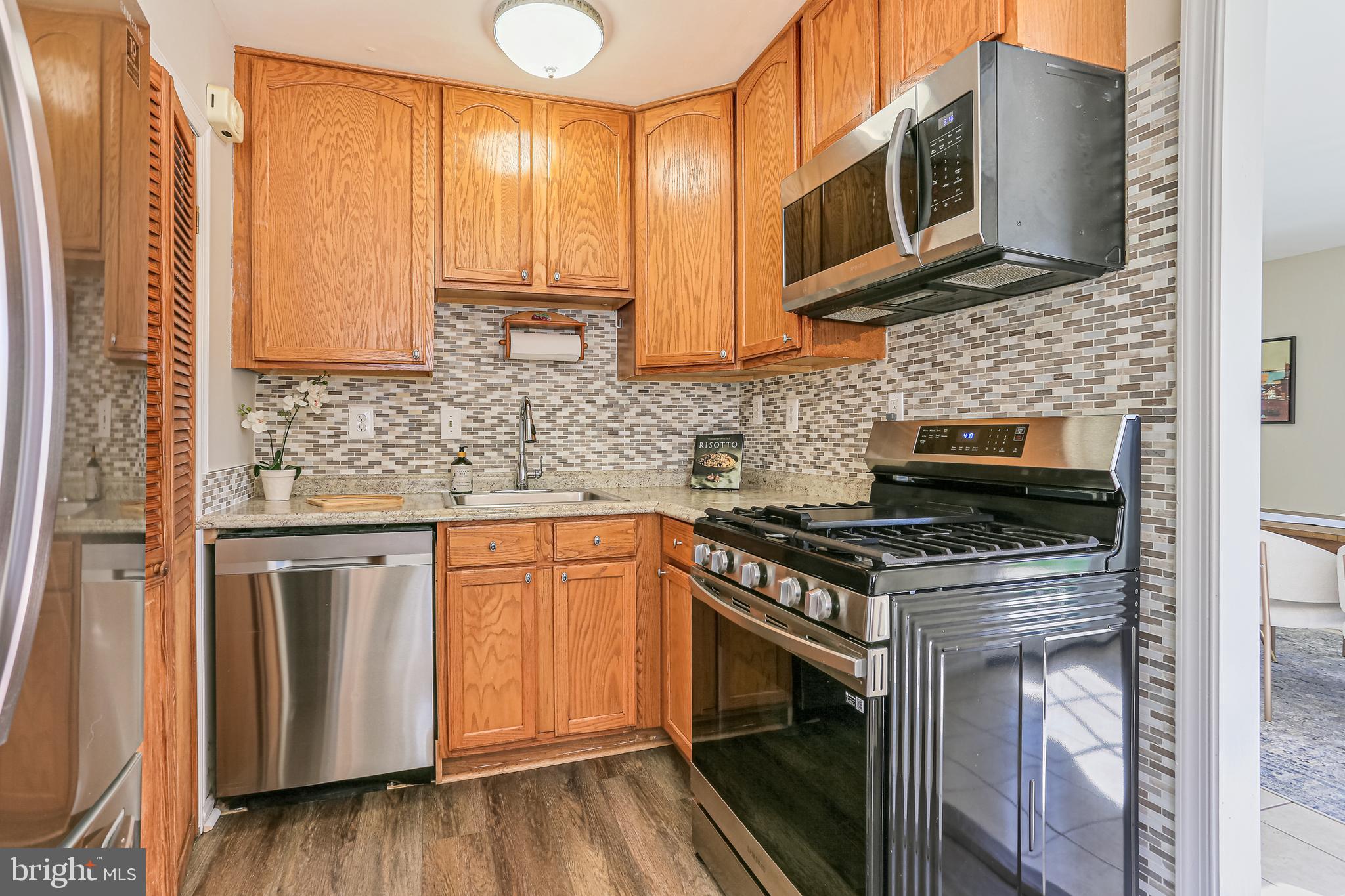 9939 Cottrell Terrace Silver Spring, MD 20903 - Photo 7 of 33 a kitchen with stainless steel appliances granite countertop a stove a sink and a microwave