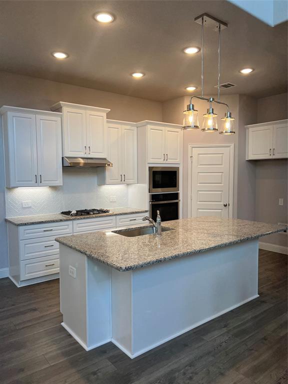 3610 Pacific Way Sachse, TX 75048 - Photo 5 of 23 a kitchen with kitchen island granite countertop a sink a counter space appliances and cabinets