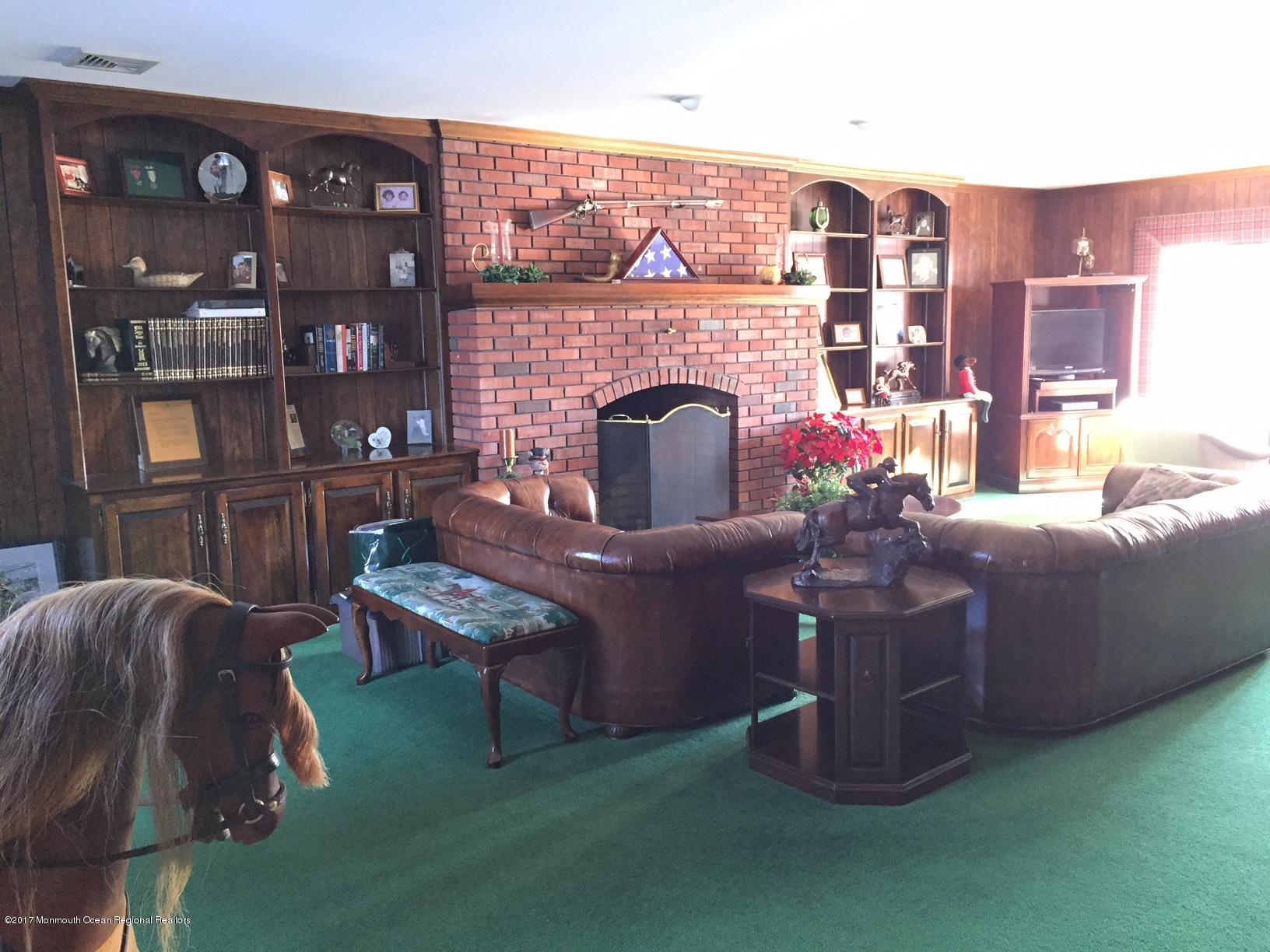 176 Stone Hill Road Colts Neck, NJ 07722 - Photo 7 of 26 a living room with furniture a fireplace and a flat screen tv