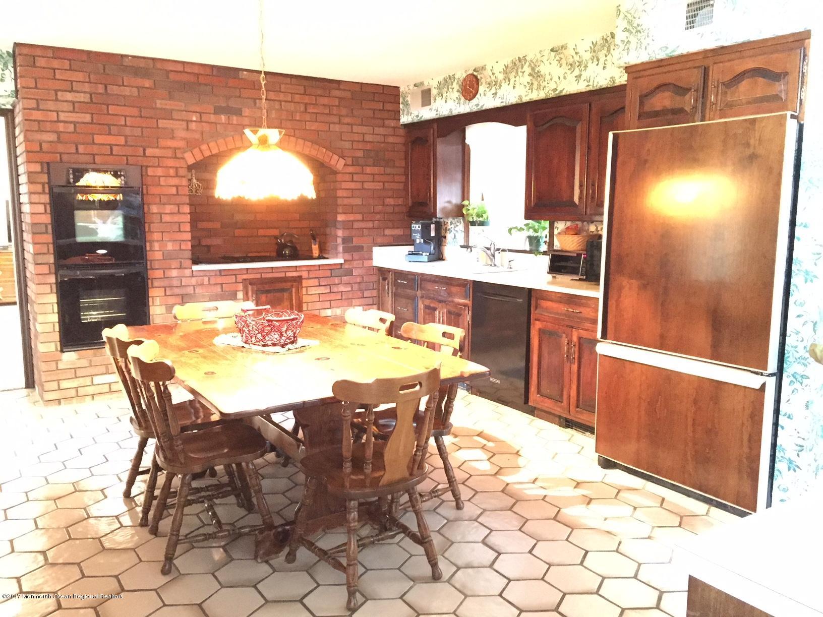 176 Stone Hill Road Colts Neck, NJ 07722 - Photo 10 of 26 a dining area with a table chairs and a refrigerator
