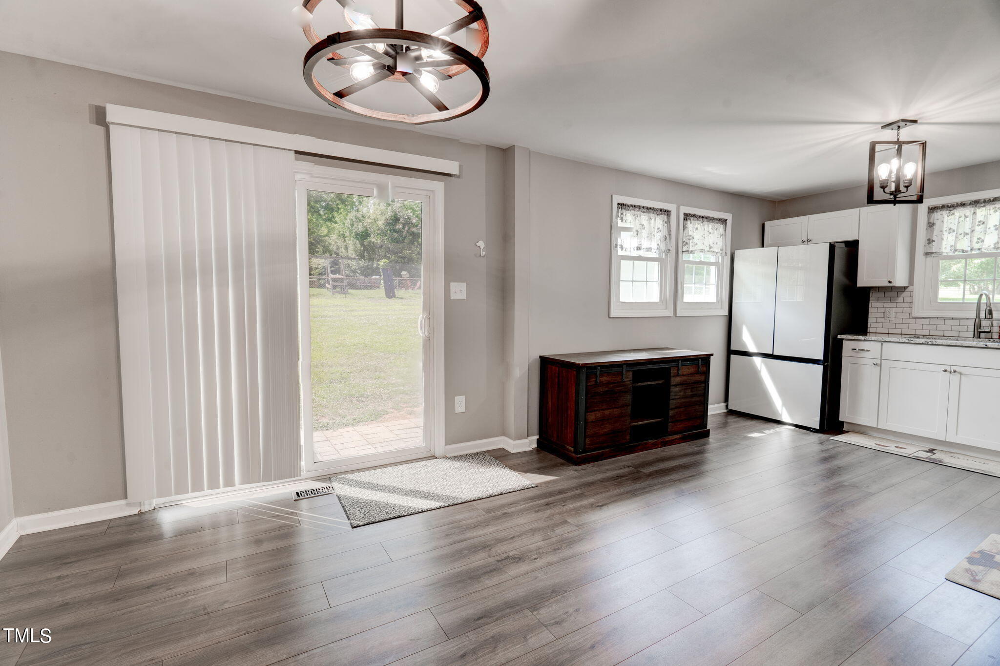 3408 High Gate Road Raleigh, NC 27603 - Photo 17 of 49 an empty room with wooden floor a kitchen view and windows