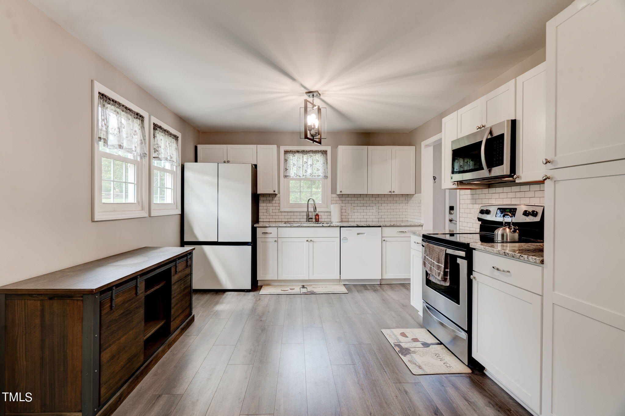 3408 High Gate Road Raleigh, NC 27603 - Photo 20 of 49 a kitchen with granite countertop a refrigerator a sink dishwasher a stove and white cabinets with wooden floor