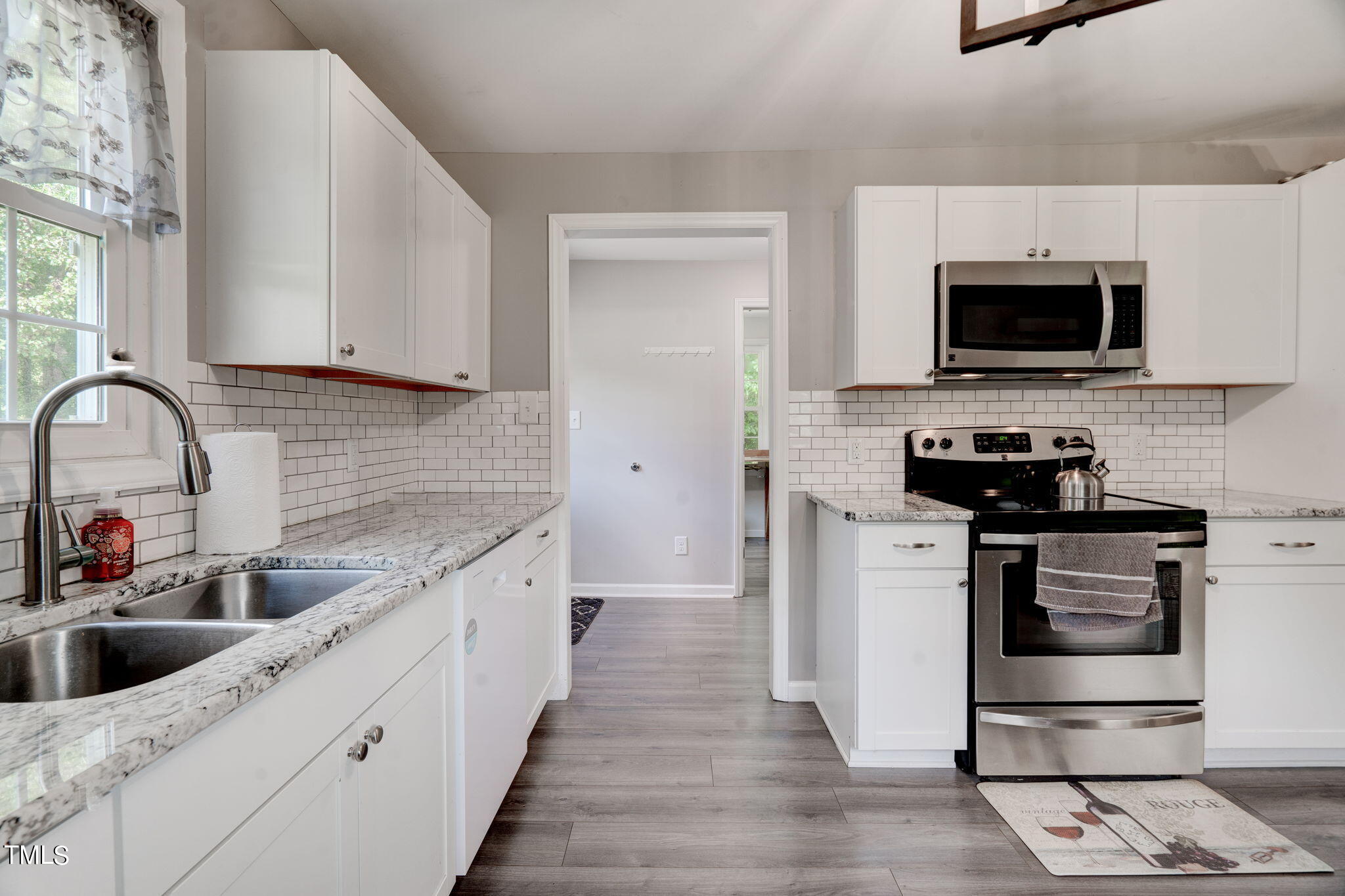 3408 High Gate Road Raleigh, NC 27603 - Photo 21 of 49 a kitchen with stainless steel appliances granite countertop a sink and a stove top oven with wooden floor