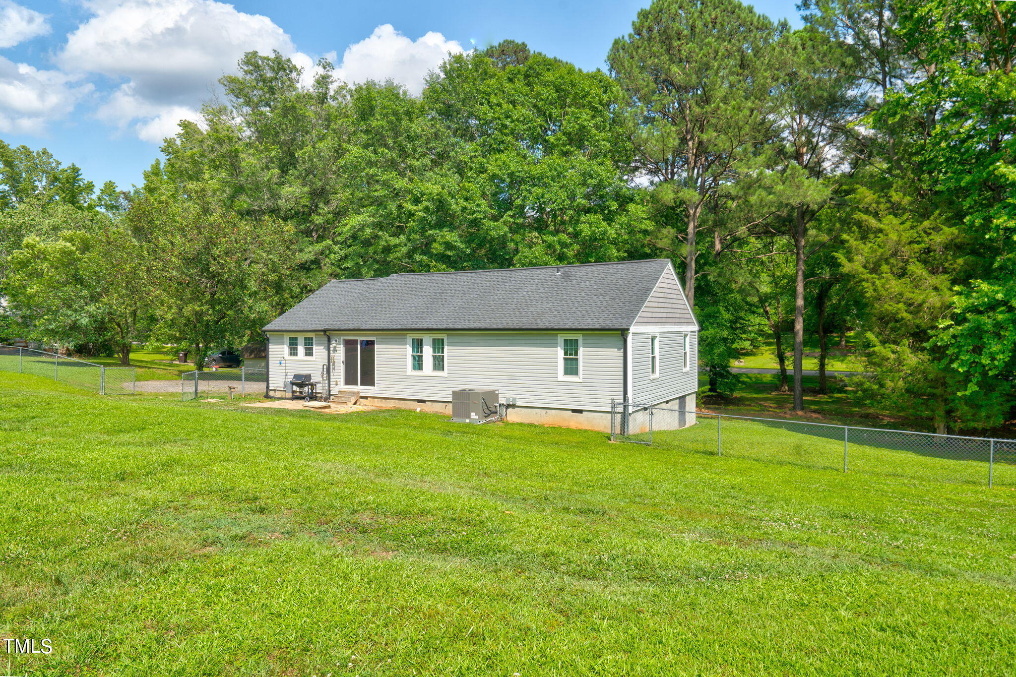 3408 High Gate Road Raleigh, NC 27603 - Photo 40 of 49 a house that is sitting in the grass with large trees and plants