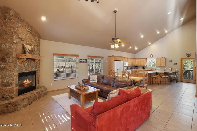 a living room with furniture a fireplace and a floor to ceiling window
