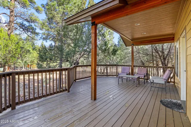 a balcony with wooden floor and outdoor seating
