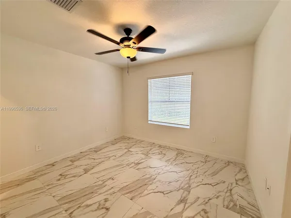 a view of a room with a ceiling fan and hardwood floor
