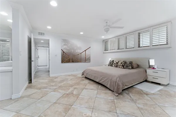 a spacious bedroom with a large bed and a chandelier