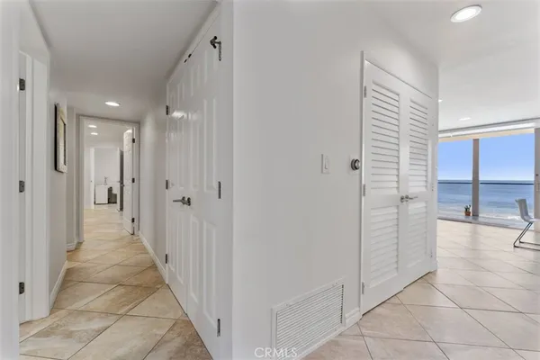 a view of a hallway with closet and chandelier
