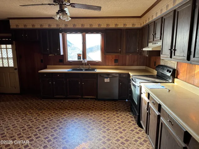 a kitchen with a sink a stove cabinets and a window