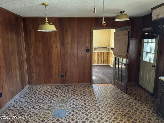 a view of a hallway with wooden floor and a chandelier