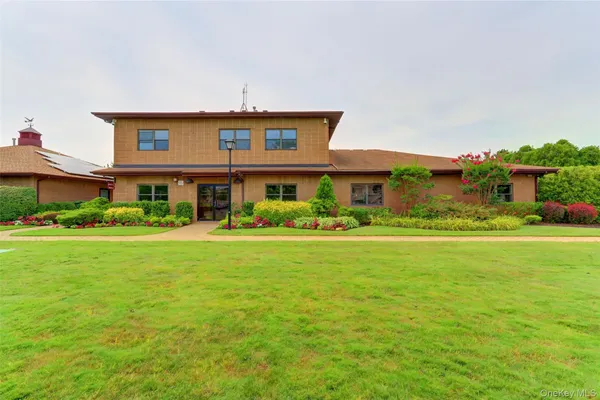 a front view of house with outdoor space and trees all around