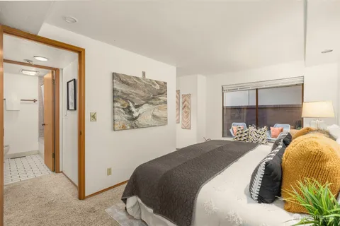 a bedroom with a bed and a painting on the wall