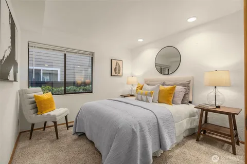 a bedroom with bed and a lamp next to a window