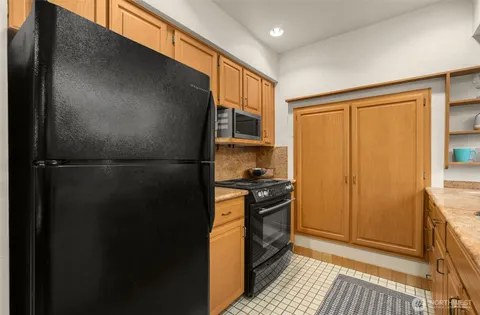 a kitchen with stainless steel appliances granite countertop a refrigerator a stove and a sink