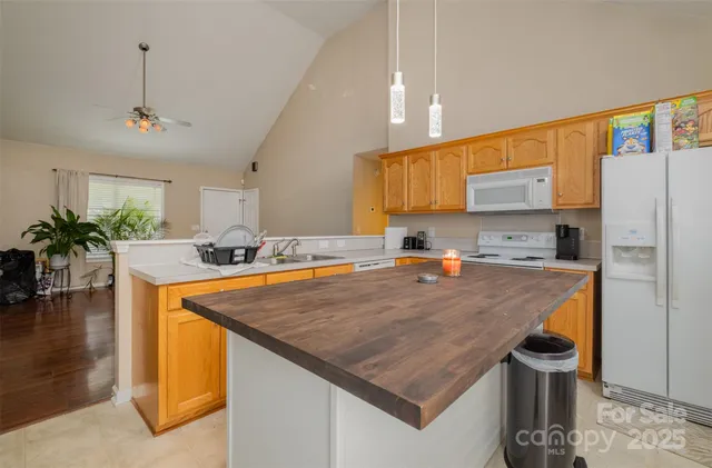 a kitchen with stainless steel appliances granite countertop a sink a refrigerator and a stove