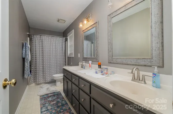 a bathroom with a double vanity sink and a mirror