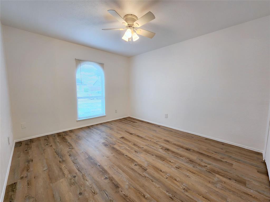 5541 Ragan Drive The Colony, TX 75056 - Photo 14 of 23 a view of a room with wooden floor and a ceiling fan