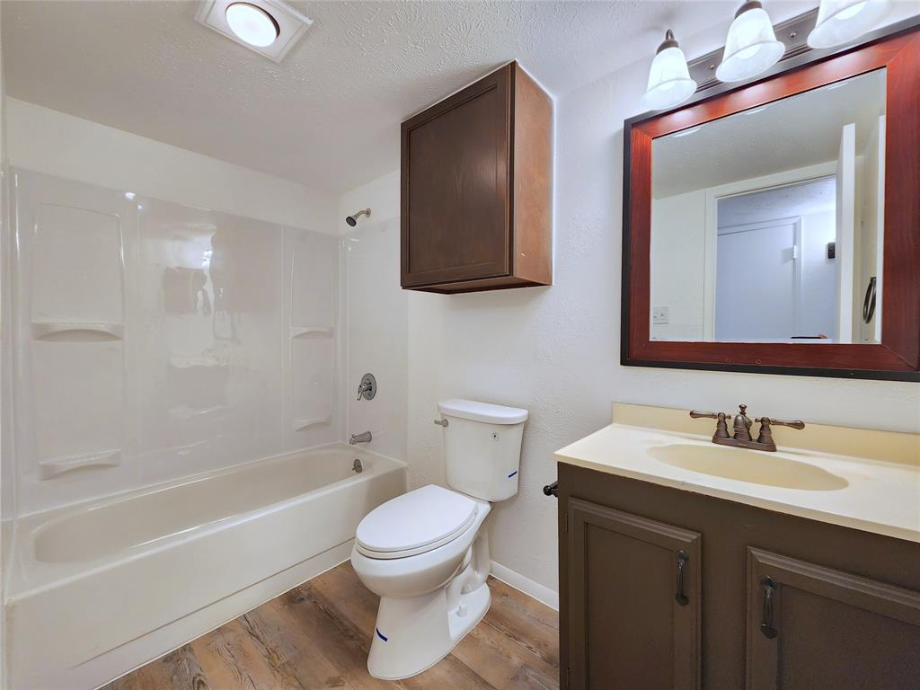 5541 Ragan Drive The Colony, TX 75056 - Photo 15 of 23 a bathroom with a toilet a sink a mirror and bathtub