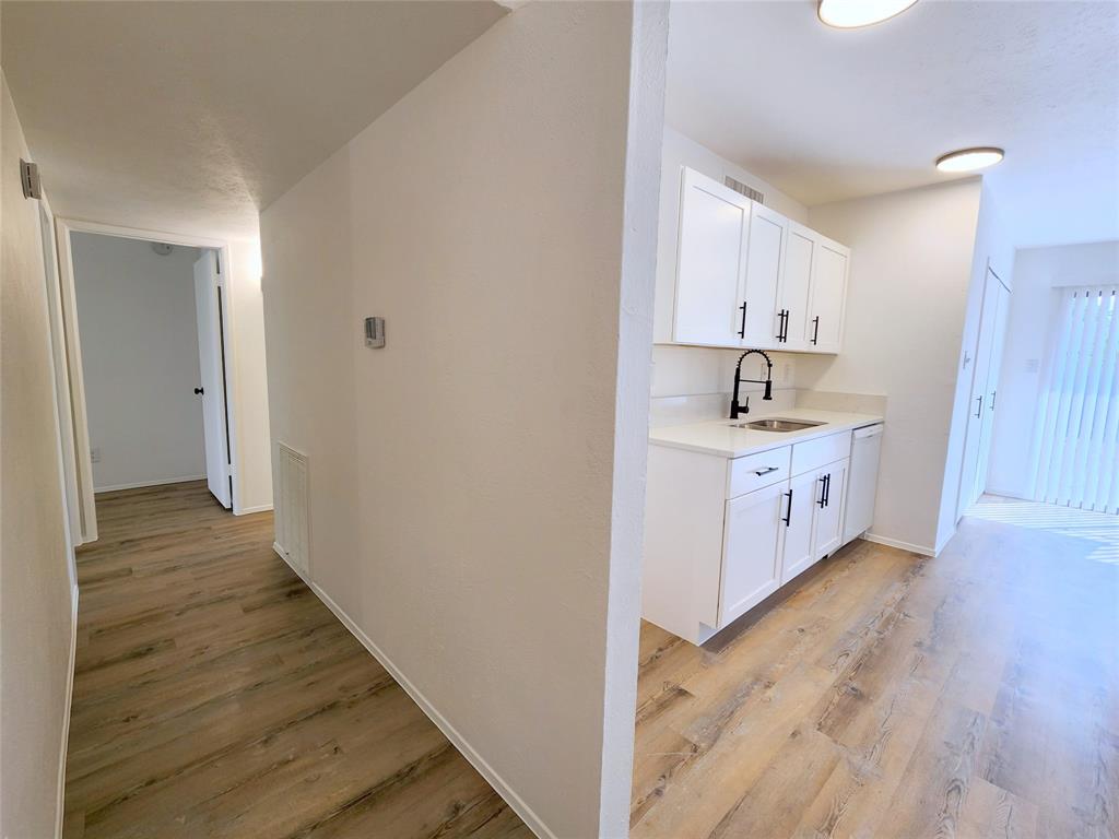 5541 Ragan Drive The Colony, TX 75056 - Photo 21 of 23 a kitchen with cabinets and wooden floor