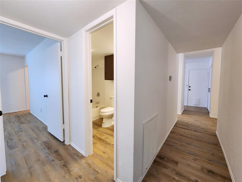 5541 Ragan Drive The Colony, TX 75056 - Photo 22 of 23 a view of a hallway with wooden floor and a bathroom