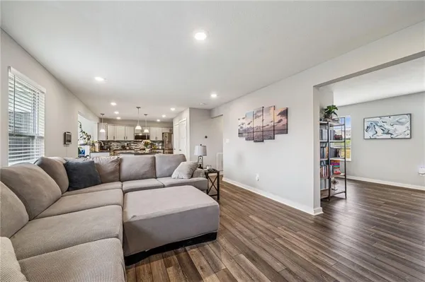 a living room with furniture and a wooden floor