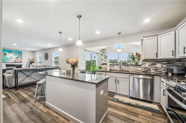 a kitchen with stainless steel appliances granite countertop a stove a sink and a refrigerator
