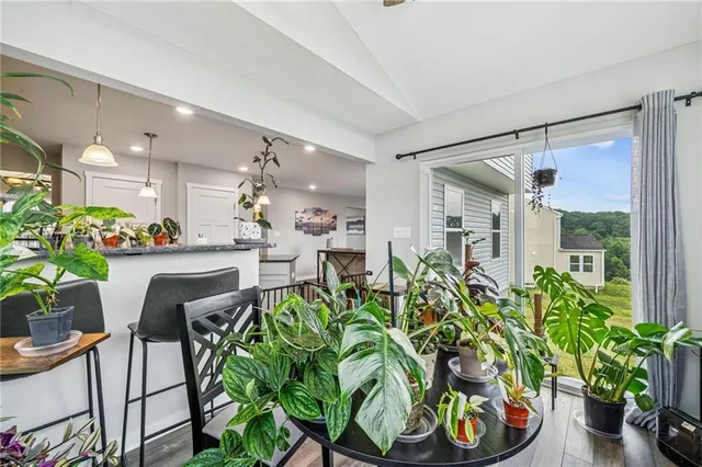 a dining room filled with furniture and potted plants