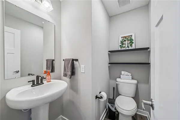 a bathroom with a toilet sink and mirror