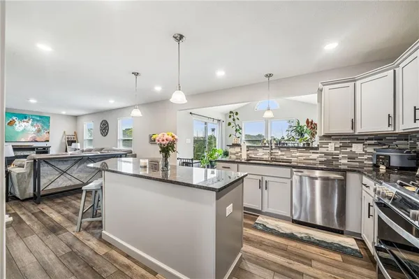 a kitchen with stainless steel appliances granite countertop a sink and stove top oven
