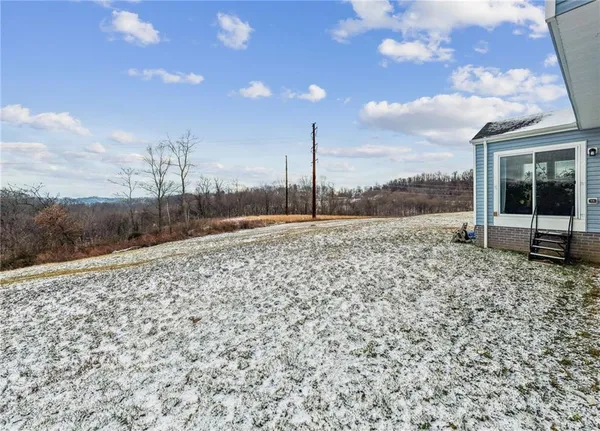 a view of a dry yard with wooden fence