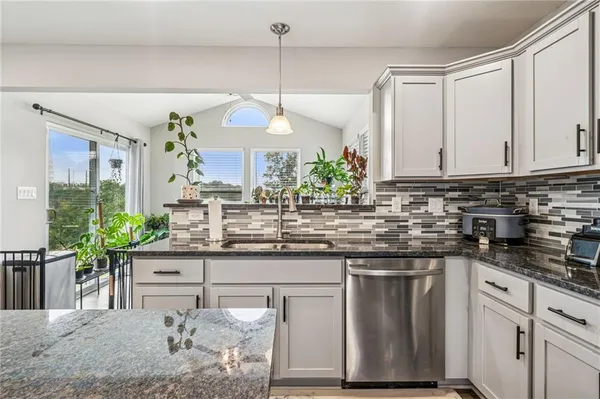 a kitchen with stainless steel appliances granite countertop a stove a sink and a refrigerator
