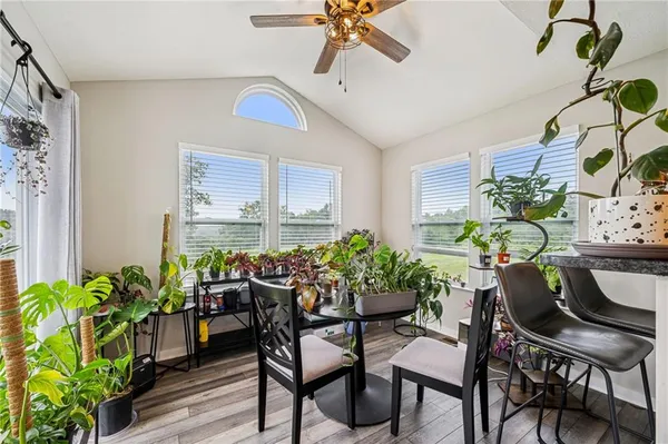 a dining room filled with furniture and potted plants