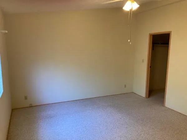 an empty room with a chandelier fan