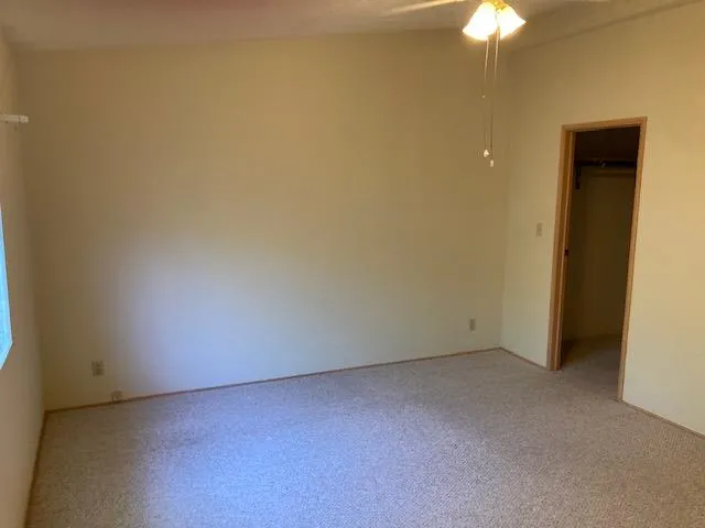 an empty room with a chandelier fan