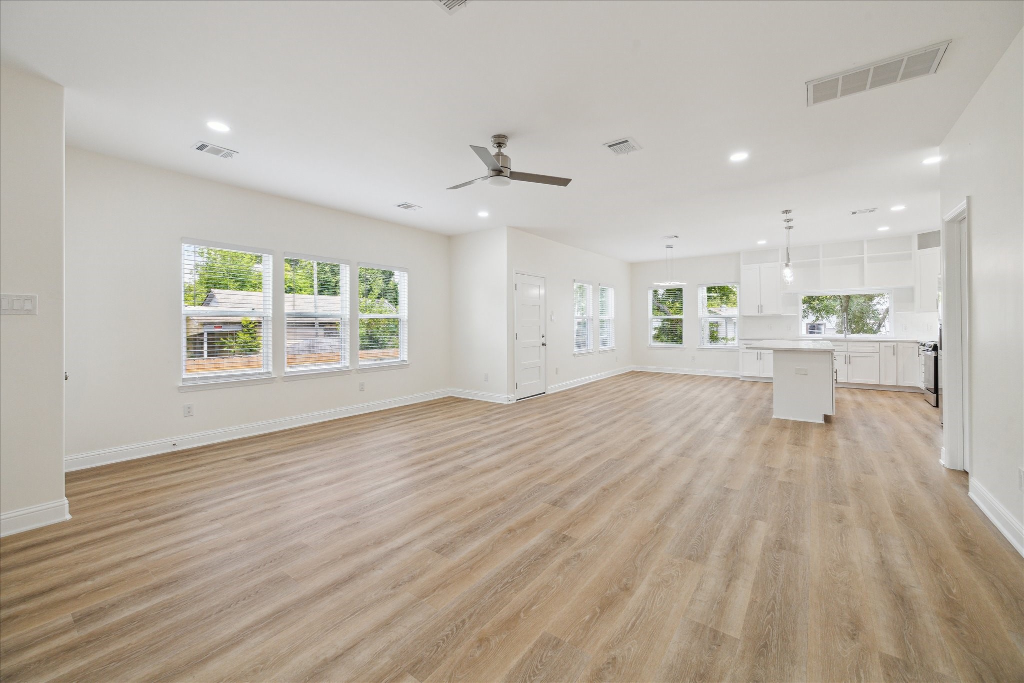 901 East 37th Street Houston, TX 77022 - Photo 5 of 19 an empty room with wooden floor a ceiling fan and windows