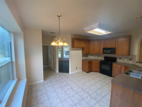 a kitchen with stainless steel appliances granite countertop a stove top oven a sink dishwasher and a microwave oven on the blue kitchen countertops