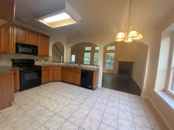 an empty room with wooden floor fireplace and windows