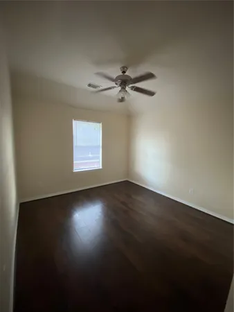a backyard of a house with plants and large tree