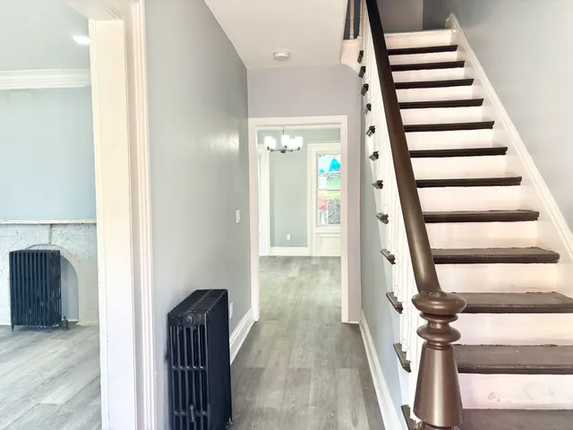 a view of a hallway with wooden floor and staircase